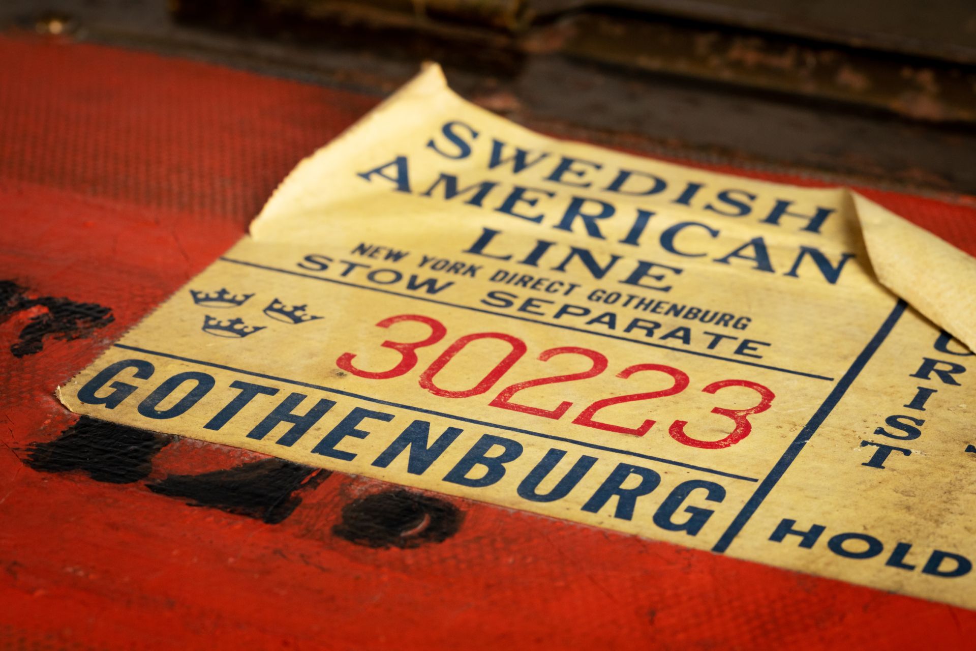 Närbild på en klisterlapp där det står Swedish American Line - svenska amerikalinjen 
