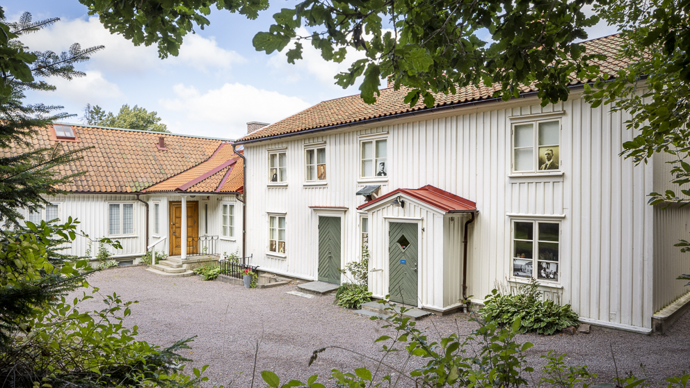 vitt hus med gårdsplan och grönska