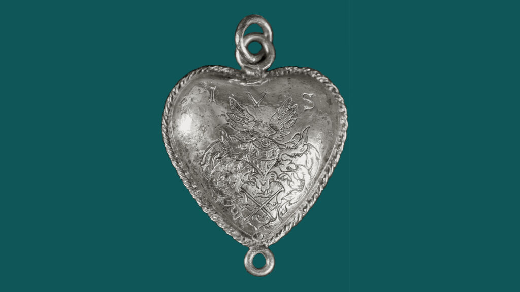 Silverhjärta med symboler och vapensköld