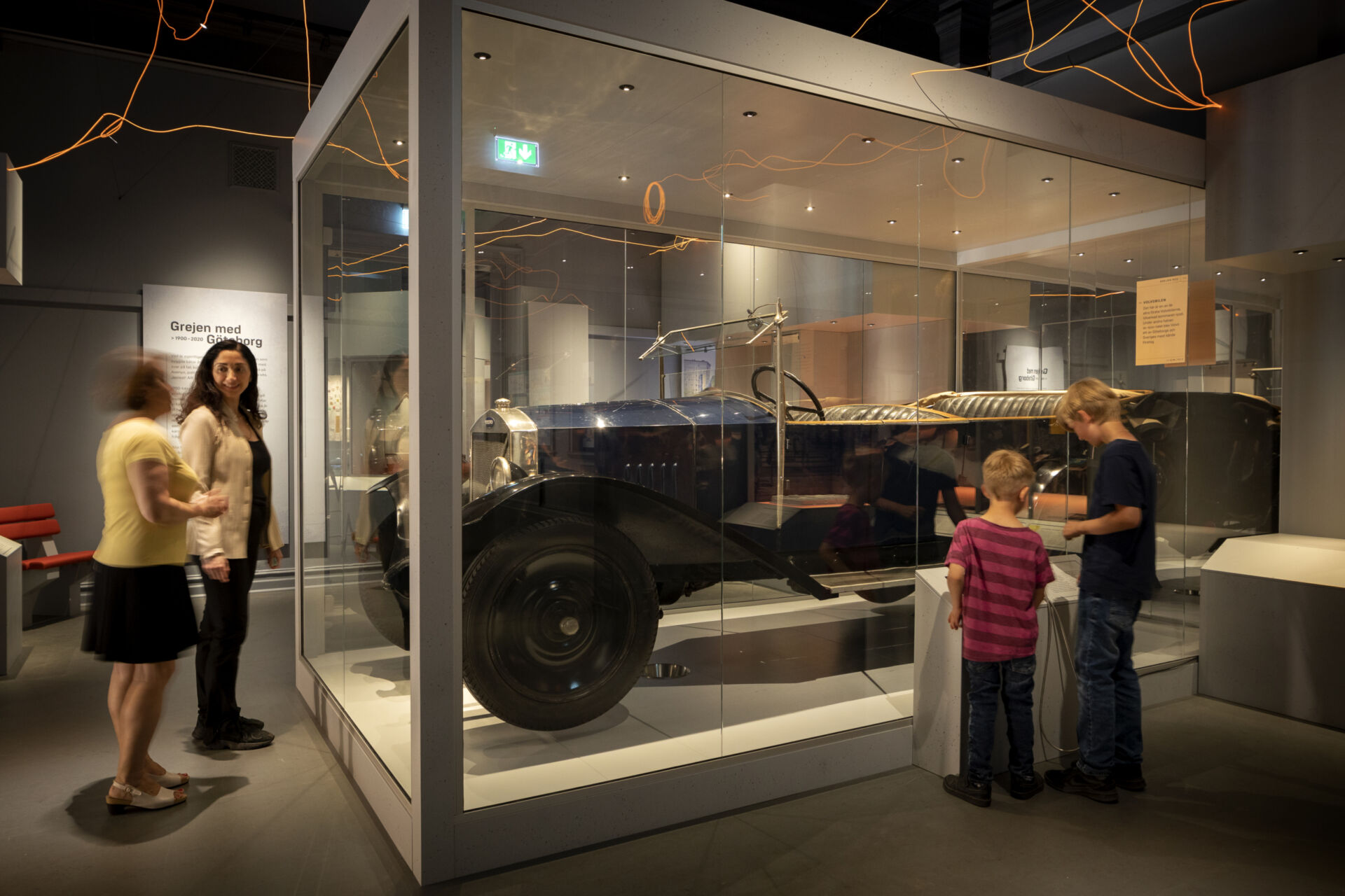 Världens första Volvo, en mörkblå öppen bil i monter och besökare
